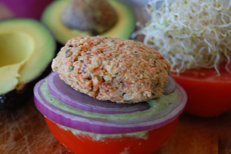 The Global Girl Raw Food Recipes: Raw Vegan Burger with a walnut patty and avocado, clover and sunflower sprouts in a tomato bun. This raw veggie burger is gluten free and oil free.