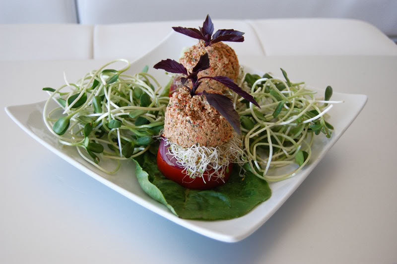 The Global Girl Raw Food Recipes: Raw Vegan Burger with a walnut patty and avocado, clover and sunflower sprouts in a tomato bun. This raw veggie burger is gluten free and oil free.