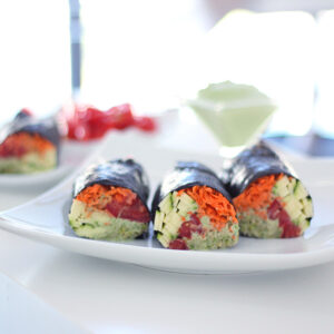 Raw vegan nori rolls with creamy cilantro sauce, shredded carrots, zucchini, tomatoes and clover sprouts. 100% gluten free, dairy free and oil free.