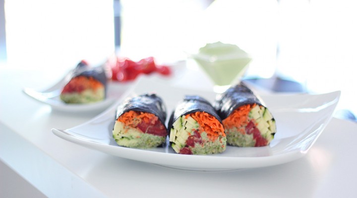 Raw vegan nori rolls with creamy cilantro sauce, shredded carrots, zucchini, tomatoes and clover sprouts. 100% gluten free, dairy free and oil free.