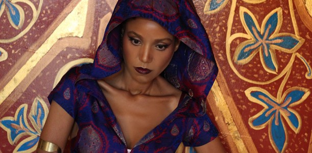 The Global Girl Editorials: Ndoema sports a silk hooded dress, tribal upper arm bracelet and pyramid studded two finger ring against vibrant gold Moroccan frescoes.