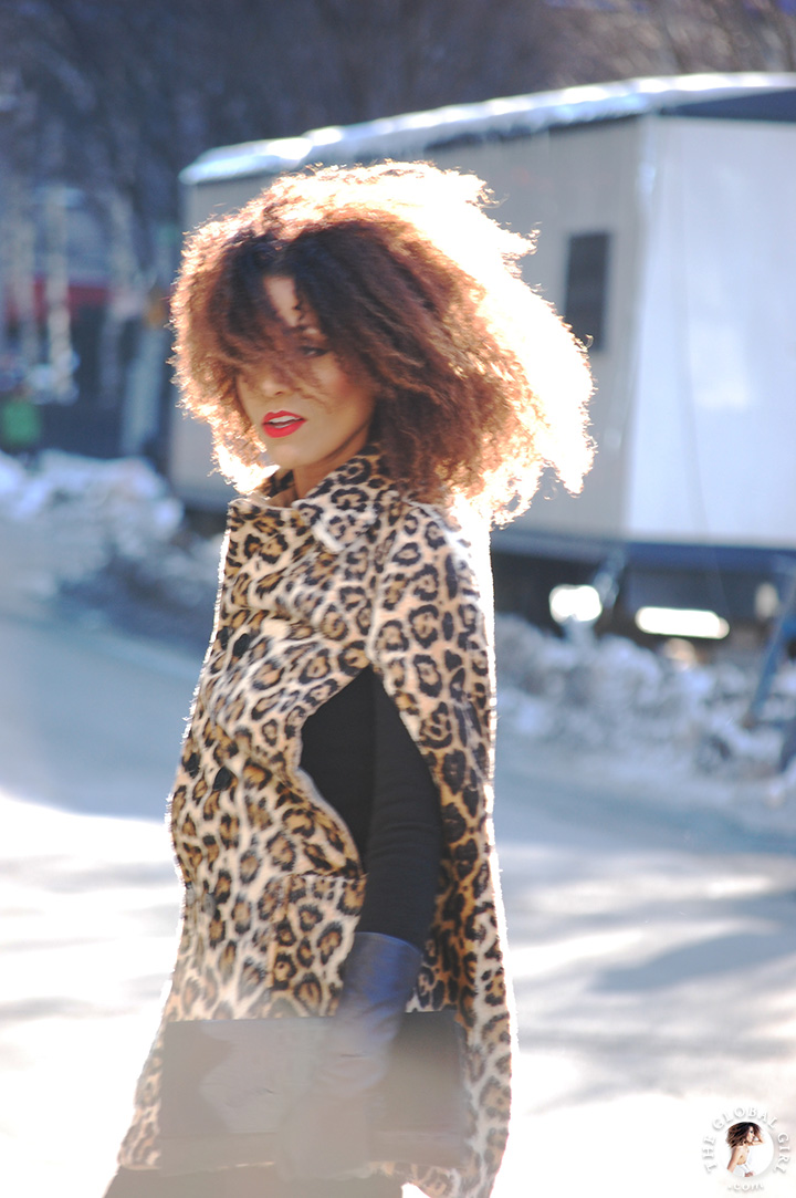 Ndoema arrives at New York Fashion Week in a bold leopard print cape and crocodile clutch.