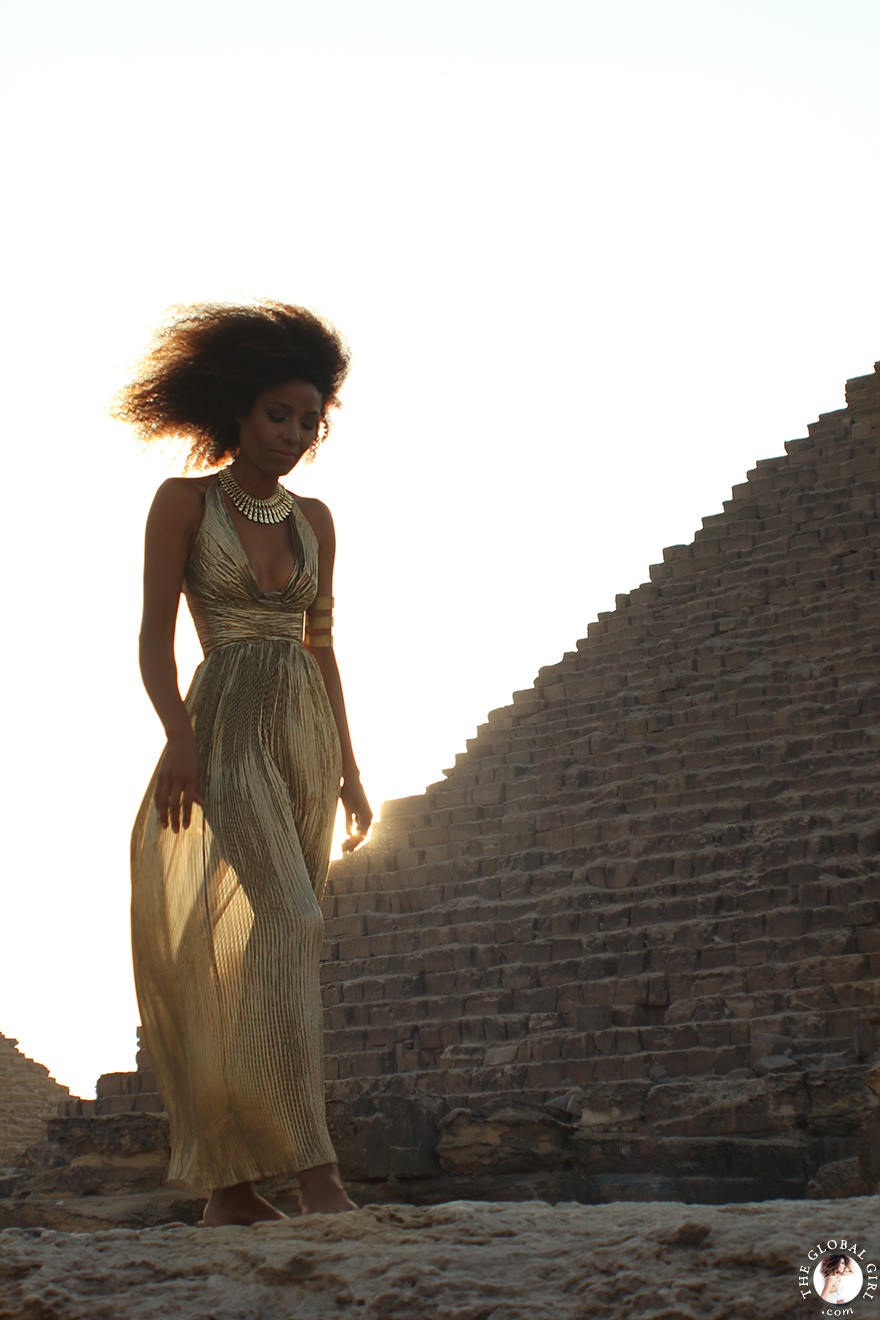 The Global Girl Travels: Ndoema in a goddess gold lame gown by Vicky Tiel at the Giza Pyramids in Egypt.