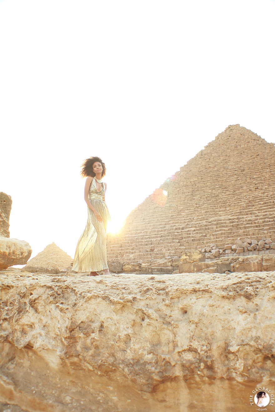 The Global Girl Travels: Ndoema in a goddess gold lame gown by Vicky Tiel at the Giza Pyramids in Egypt.