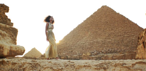 The Global Girl Travels: Ndoema in a goddess gold lame gown by Vicky Tiel at the Giza Pyramids in Egypt.