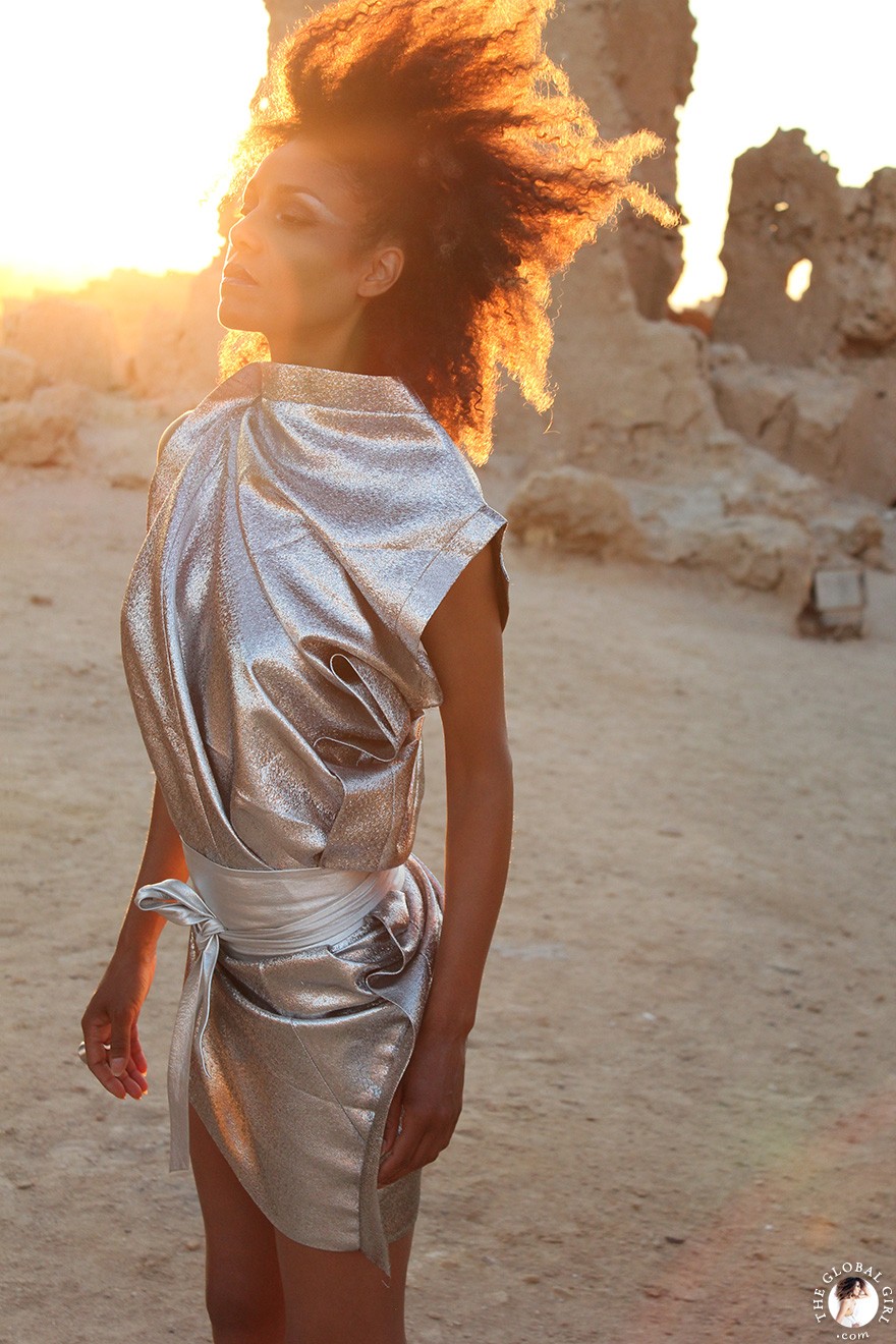 The Global Girl Fashion Editorials: Ndoema goes futuristic in a silver metallic dress against the ancient ruins of Shali Ghadi, a spectacular 13th-century fortress at Siwa Oasis, Egypt. 
