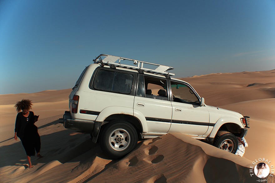 The Global Girl Travels: Four-wheel drive land cruiser stuck on a sand dune in the Libyan desert on a safari in the sahara, North Africa.