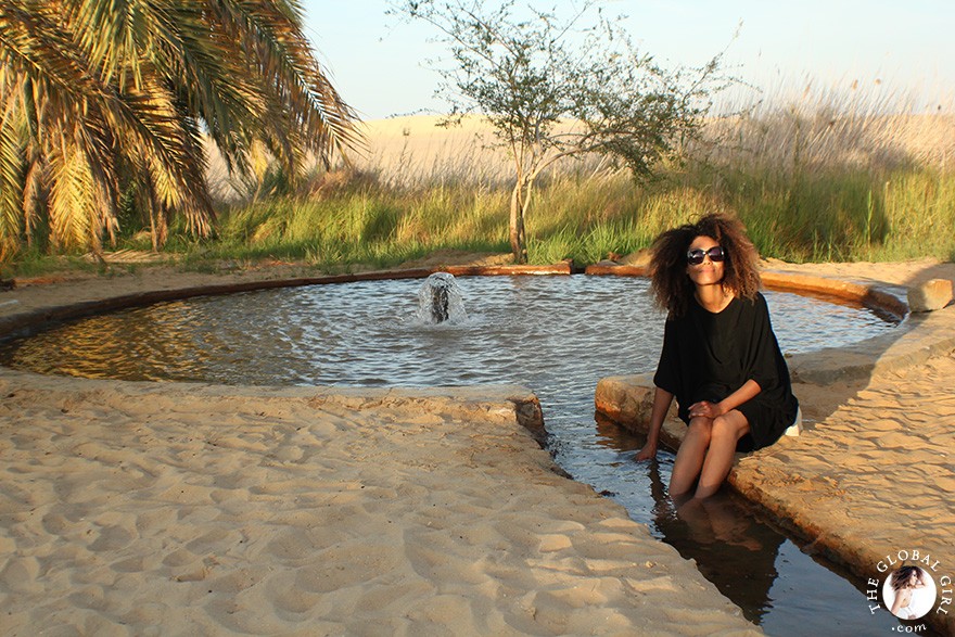 The Global Girl Travels: Ndoema soaking in the healing sulfur natural springs at the beautiful freshwater lake at Bir Wahed, a striking natural landmark on the edge of the Great Sand Sea, a 72,000 km² sand desert region in North Africa stretching between western Egypt and eastern Libya.