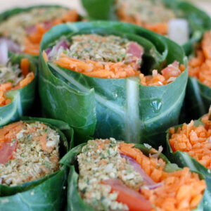 The Global Girl Raw Vegan Recipes: Veggie Wrap with Pumpkin Seed & Mint Patty in a collard green leaf with tomato, shredded carrot, red onion and sprouts.